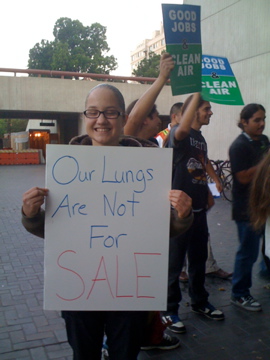Woman holding sign that says "Our Lungs are Not for Sale"